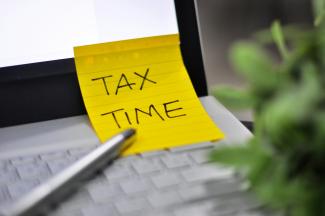 Yellow sticky note with tax time written on it. by Supannee U-prapruit courtesy of Unsplash.
